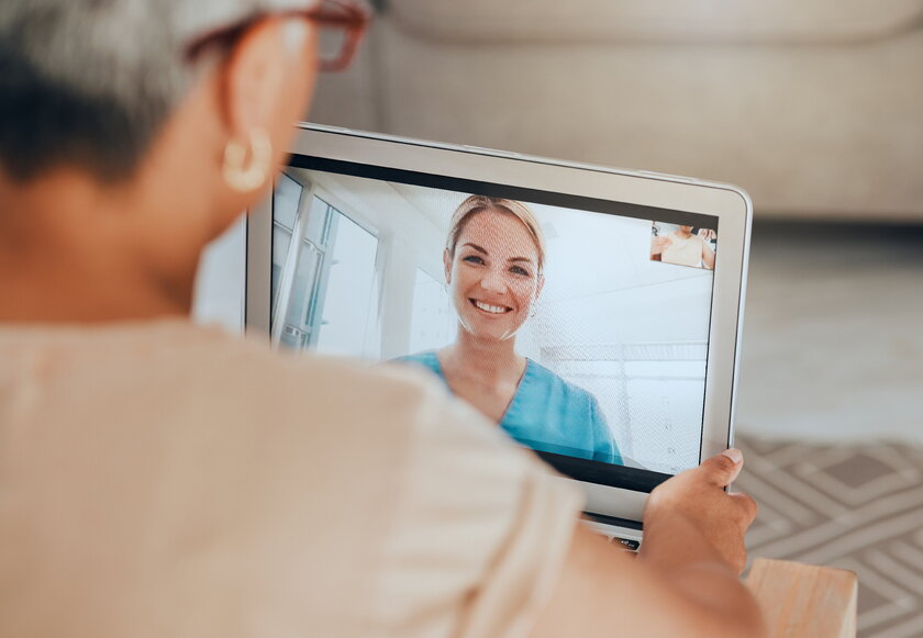 Seniorin bespricht sich am Tablet mit Hausaerztin via Telemedizin.