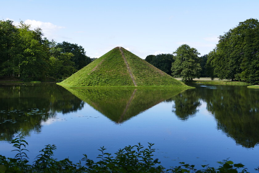 Blick auf von Wasser umgebene Branitz-Pyramide im Fuerst-Pueckler-Park in Cottbus.